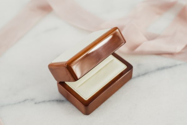 Pudełko przeznaczone na pierścionek zaręczynowy, wykonane z lakierowanego drewna.  Środek ekoskóra biała.